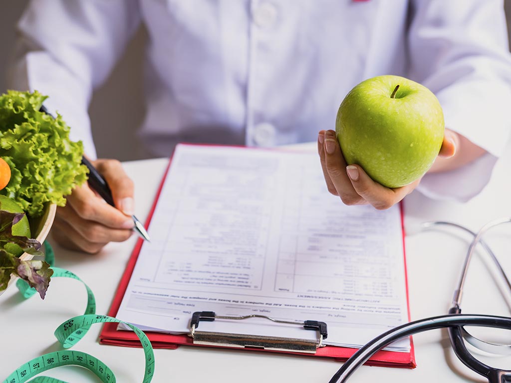 Nutritionist with healthy fruit, vegetable and measuring tape working, Right nutrition and diet concept