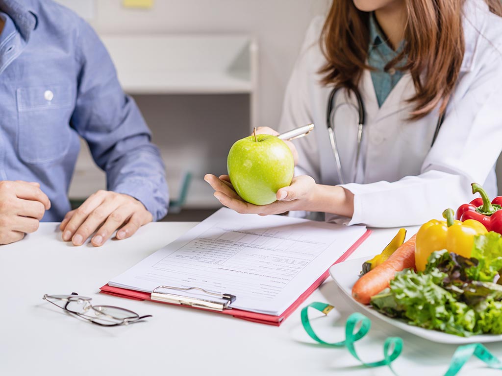 Nutritionist giving consultation to patient with healthy fruit and vegetable, Right nutrition and diet concept